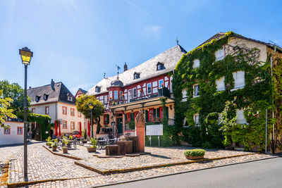 Houses by street in town against blue sky