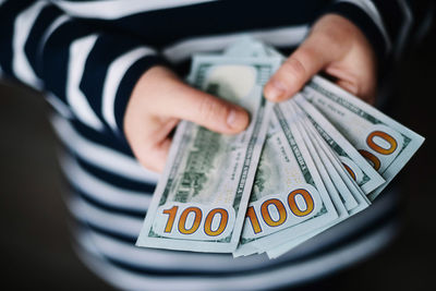 Midsection of woman holding paper currency