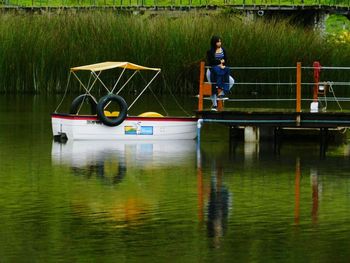 Reflection of man in boat on lake