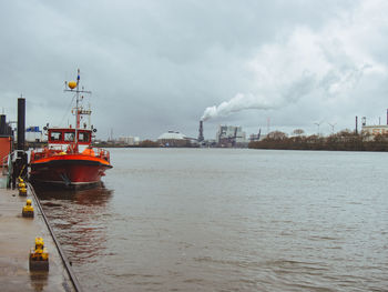 Boat moored at river against sky