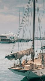 Sailboats moored at harbor against sky