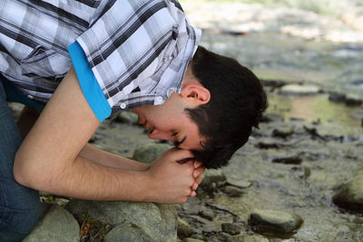 Side view portrait of young man with water