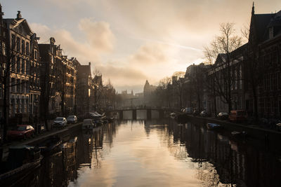 River amidst cityscape against sky