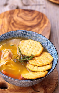 High angle view of soup with crackers on wooden table