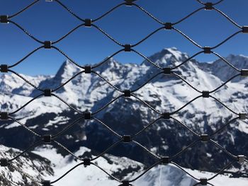 Full frame shot of chainlink fence against mountain during winter