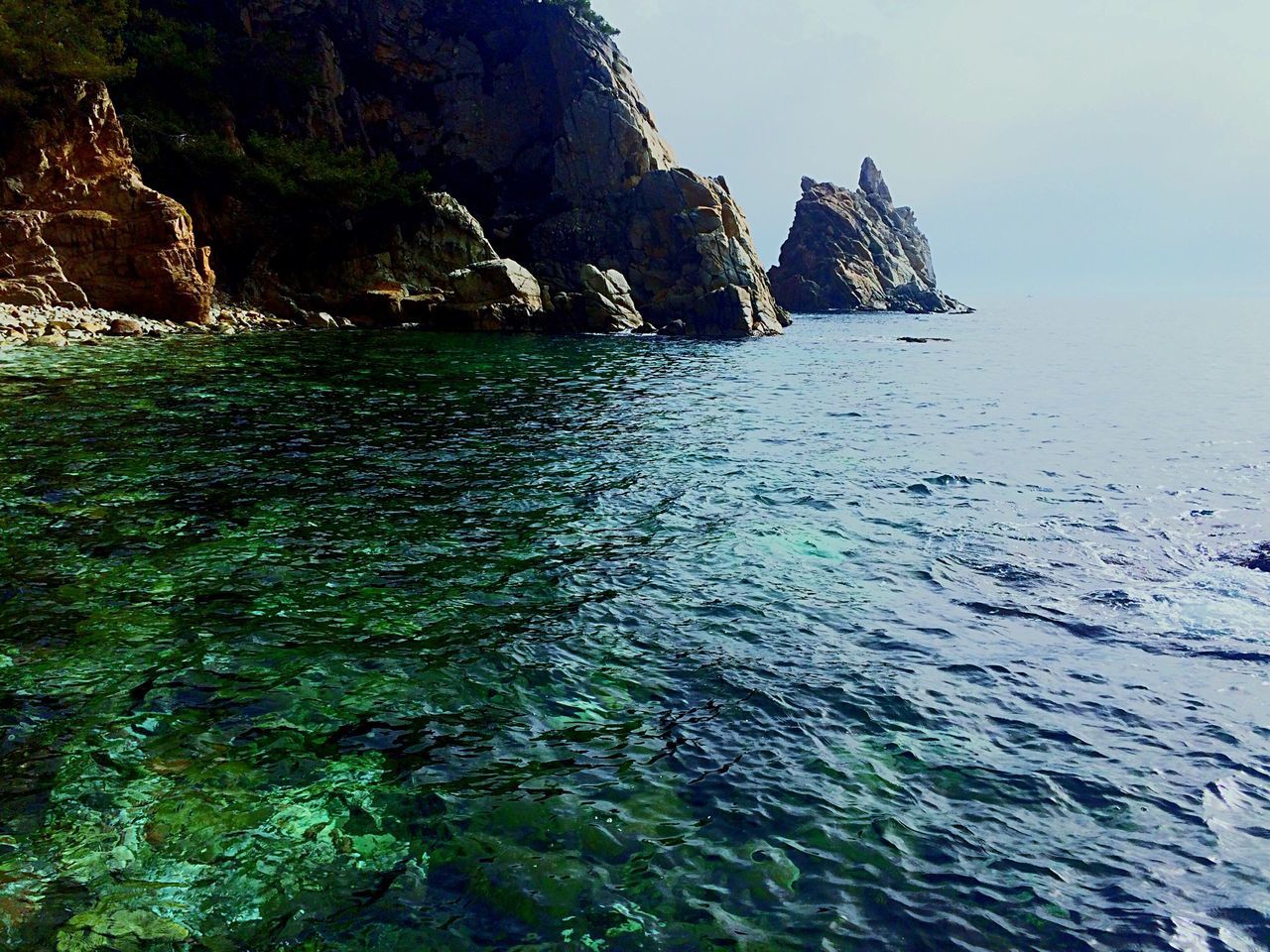 water, sea, rock formation, rock - object, tranquil scene, scenics, tranquility, cliff, beauty in nature, nature, mountain, sky, waterfront, rock, clear sky, idyllic, rippled, day, non-urban scene, outdoors