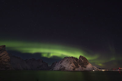 Scenic view of lake and mountains against sky at night