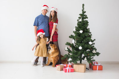 Full length of woman with dog on christmas tree