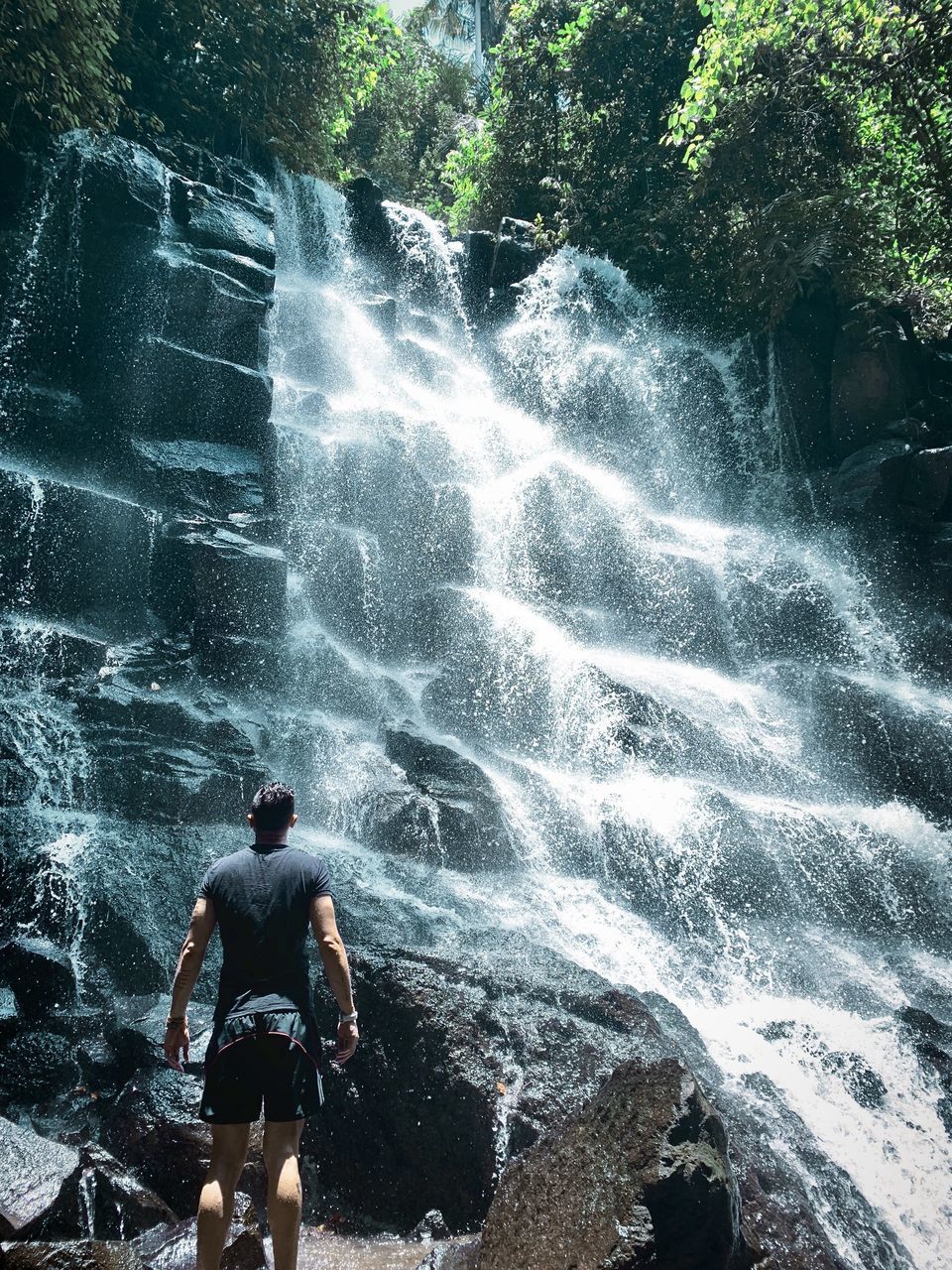 FULL LENGTH OF SHIRTLESS MAN STANDING ON ROCKS