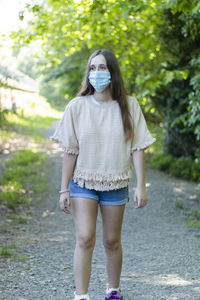 Full length portrait of young woman standing outdoors