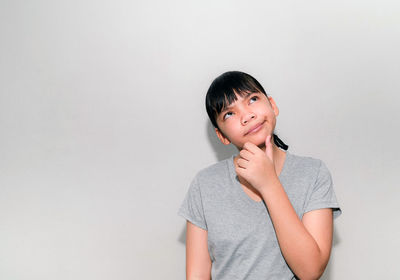 Portrait of smiling young woman against white background