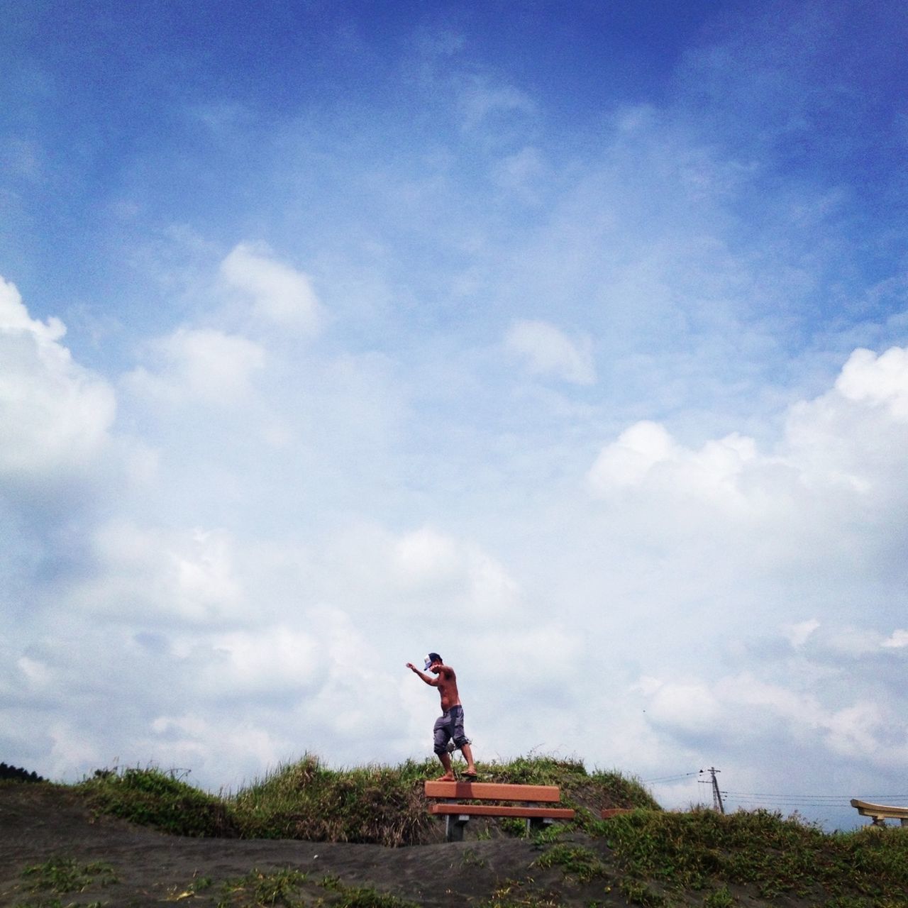 sky, cloud - sky, leisure activity, lifestyles, sitting, cloudy, men, cloud, full length, tranquility, sculpture, nature, grass, statue, human representation, landscape, tranquil scene, outdoors