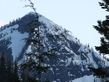 Low angle view of snow and mountains against sky