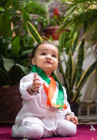 Cute toddler holding indian tricolor flag in traditional cloth with innocent facial expression