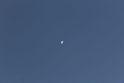 Low angle view of moon against blue sky