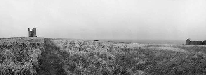 Panoramic view of lighthouse on field against sky