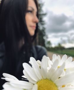 Close-up portrait of woman with pink flower