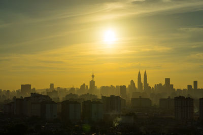 Petronas towers with cityscape against sky during sunset