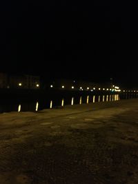 Illuminated street lights against clear sky at night