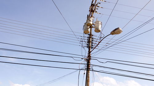 Low angle view of electricity pylon against sky