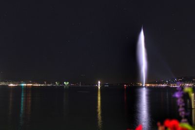 Illuminated city against sky at night