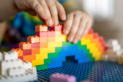 Cropped hands of kid playing with building blocks