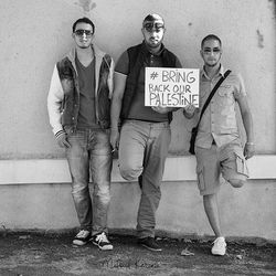 Portrait of friends standing against wall