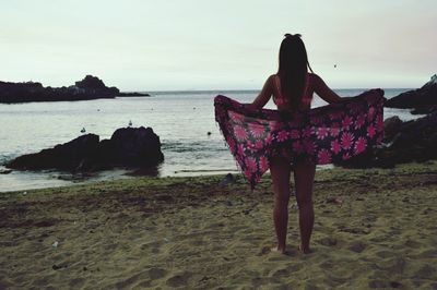 Rear view of woman walking on beach