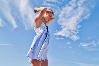 Low angle view of woman standing against sky