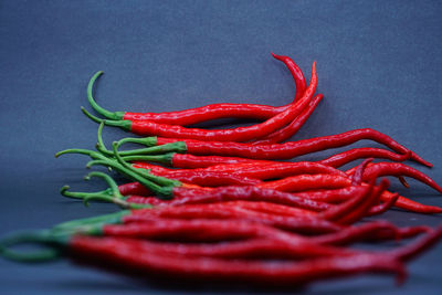 Close-up of red chili peppers against blue background