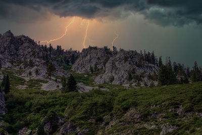 Scenic view of lightning over mountains against sky