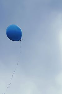 Low angle view of balloons against blue sky