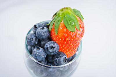 Close-up of fruits in bowl against white background