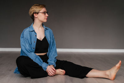 Young woman standing against wall