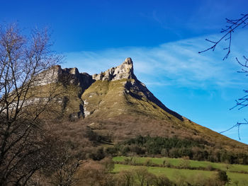 Low angle view of mountain against blue sky