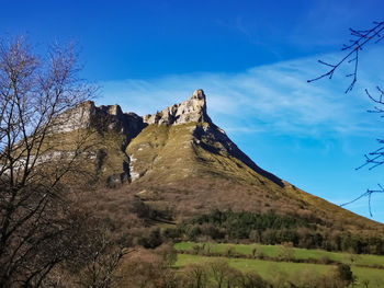 Low angle view of mountain against blue sky