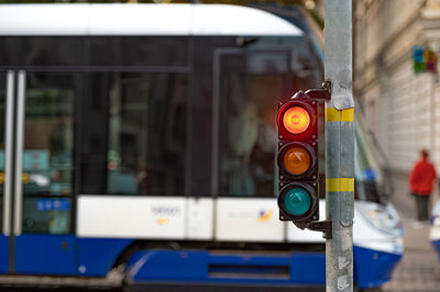 Blurred view of city traffic with traffic lights, in the foreground a semaphore with a red light