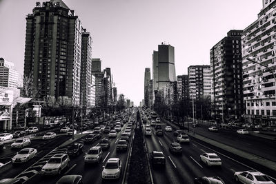 High angle view of traffic on road amidst modern buildings in city against clear sky