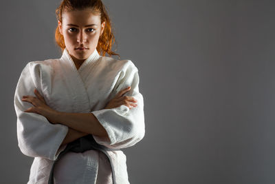 Portrait of a young woman against black background