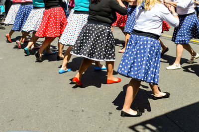 Low section of women dancing on street during sunny day