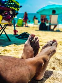 Low section of people relaxing on beach