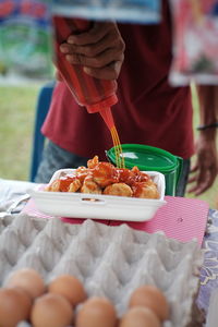 Close-up of man preparing food at market stall