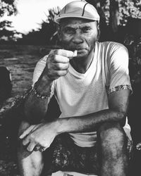 Portrait of man holding paper sitting outdoors