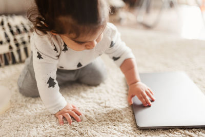 Rear view of boy playing on rug at home