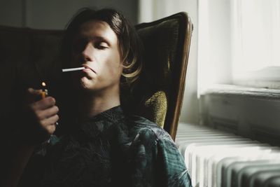 Man smoking cigarette at home