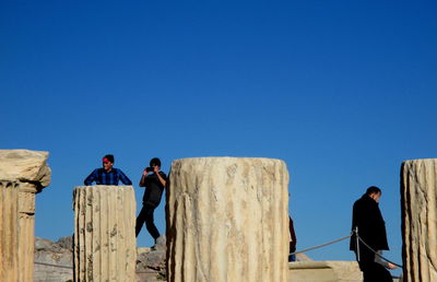Woman standing against clear blue sky