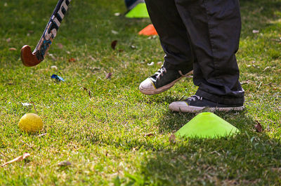 Low section of man playing hockey on field