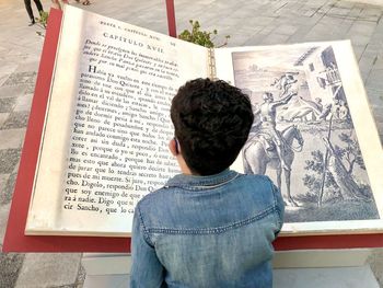 Rear view of boy with open book