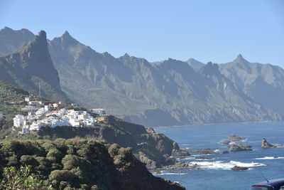 Scenic view of sea and mountains against clear sky