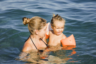 Happy boy and woman in water